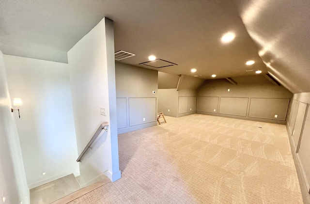 additional living space with light colored carpet and lofted ceiling