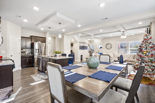 dining room with beamed ceiling, ceiling fan, dark hardwood / wood-style floors, and sink