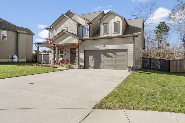 view of front of home featuring a garage, a front yard, and covered porch