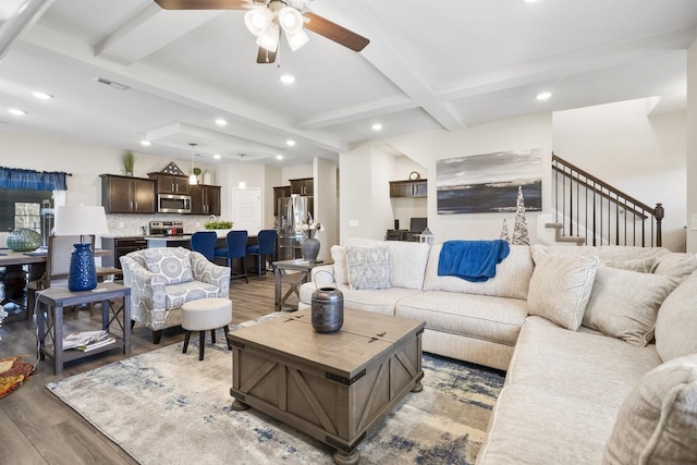 living room featuring beam ceiling, wood-type flooring, and ceiling fan