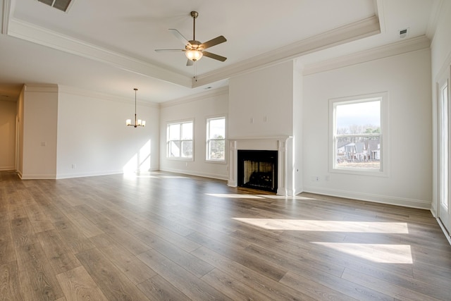 unfurnished living room featuring a tray ceiling, ceiling fan with notable chandelier, ornamental molding, and hardwood / wood-style flooring