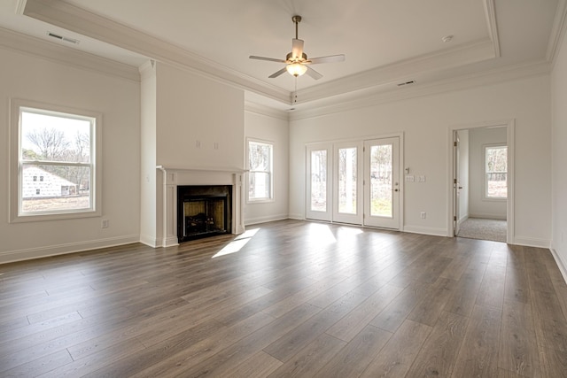 unfurnished living room featuring a tray ceiling, ornamental molding, dark hardwood / wood-style floors, and ceiling fan