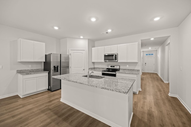 kitchen featuring appliances with stainless steel finishes, sink, an island with sink, and white cabinets