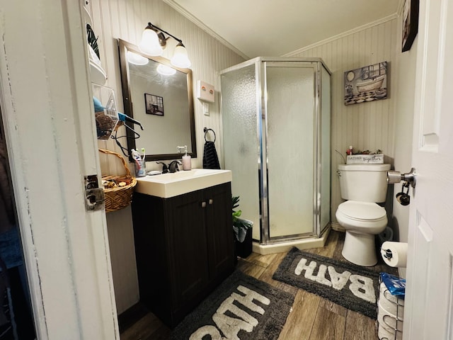 bathroom with walk in shower, toilet, crown molding, vanity, and hardwood / wood-style flooring