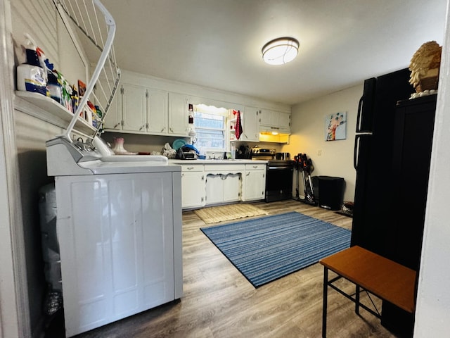 clothes washing area with sink, independent washer and dryer, and light wood-type flooring