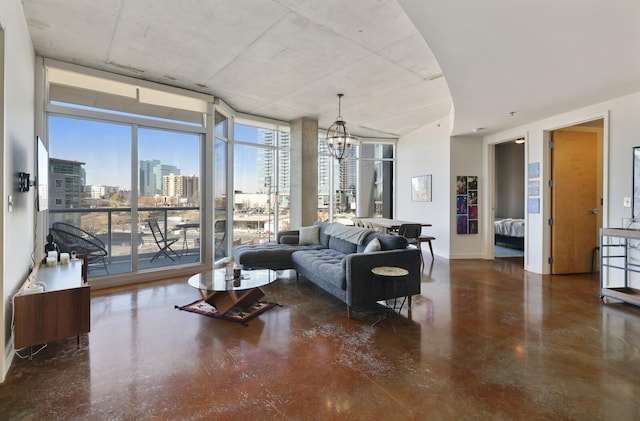 living room with expansive windows, a notable chandelier, and baseboards