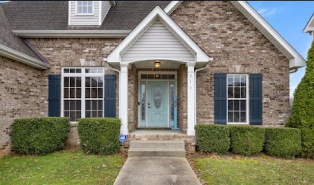 entrance to property featuring brick siding