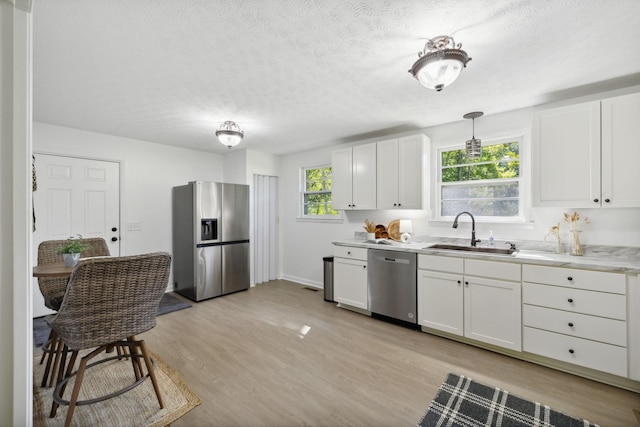 6992 Mill Creek Rd, Lyles, TN 37098 - kitchen featuring white cabinets, appliances with stainless steel finishes, light countertops, and pendant lighting