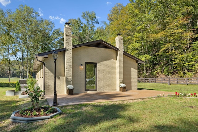 6992 Mill Creek Rd, Lyles, TN 37098 - back of property featuring brick siding, a chimney, a lawn, a patio area, and fence