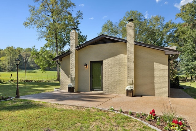 6992 Mill Creek Rd, Lyles, TN 37098 - rear view of property with a patio area, a chimney, a lawn, and brick siding