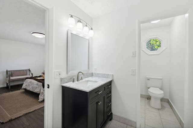 6992 Mill Creek Rd, Lyles, TN 37098 - ensuite bathroom featuring ensuite bathroom, a textured ceiling, toilet, vanity, and baseboards