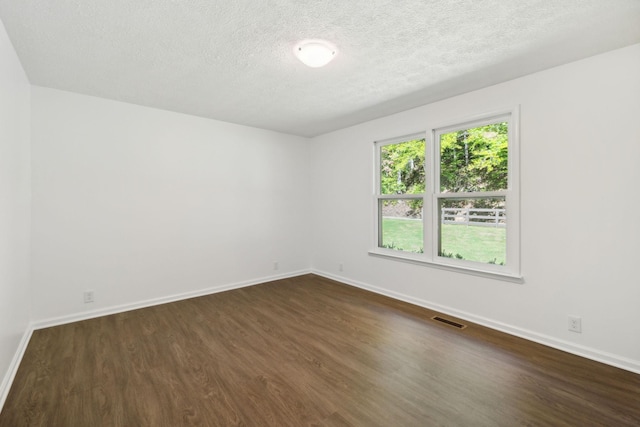 6992 Mill Creek Rd, Lyles, TN 37098 - empty room with dark wood-style floors, visible vents, a textured ceiling, and baseboards