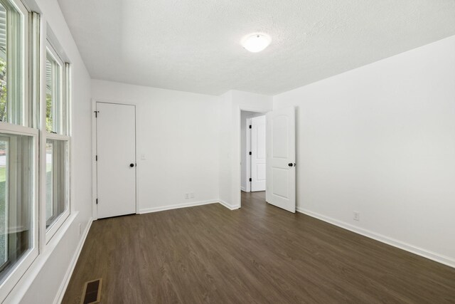 6992 Mill Creek Rd, Lyles, TN 37098 - empty room featuring dark wood-type flooring, visible vents, a textured ceiling, and baseboards