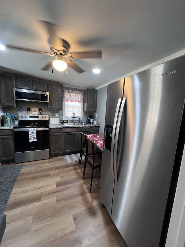 6992 Mill Creek Rd, Lyles, TN 37098 - kitchen featuring extractor fan, stainless steel appliances, dark brown cabinets, light countertops, and light wood-type flooring