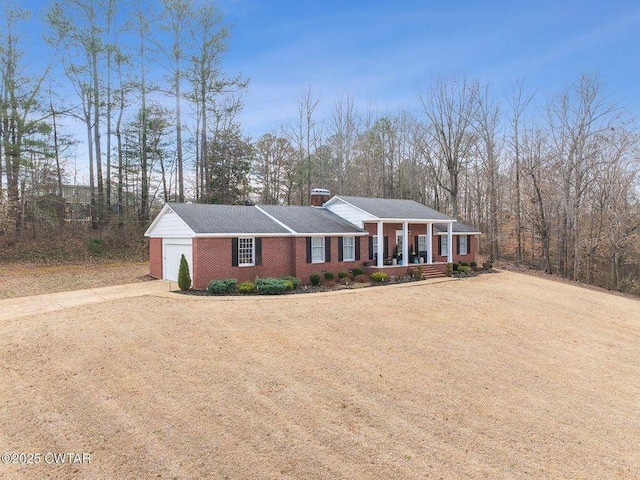 view of front of house with a garage, a front lawn, and a porch