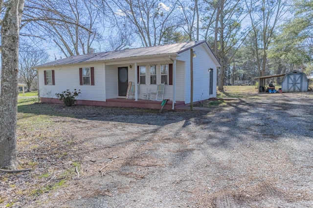 ranch-style house with a carport, a storage unit, and covered porch