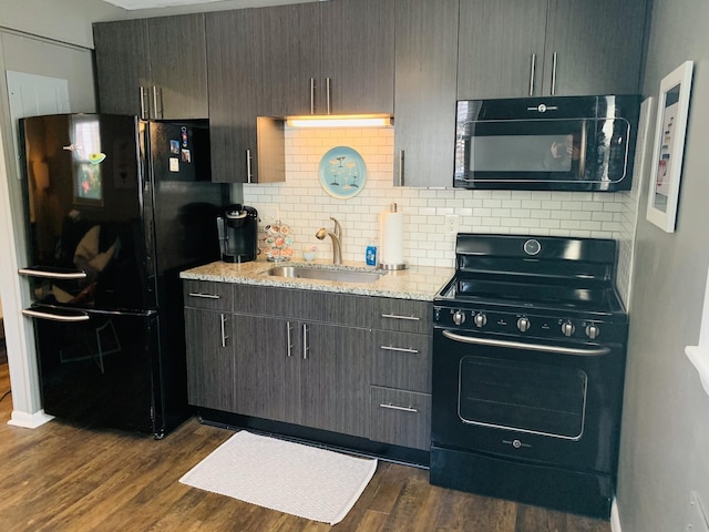 kitchen featuring light stone countertops, sink, dark wood-type flooring, and black appliances