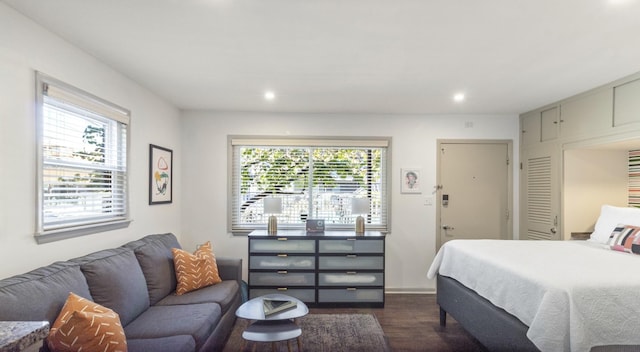 bedroom with multiple windows and dark hardwood / wood-style floors