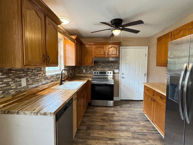 kitchen featuring sink, dark wood-type flooring, ceiling fan, stainless steel appliances, and tasteful backsplash