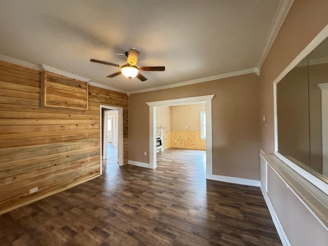 unfurnished room featuring crown molding, ceiling fan, dark hardwood / wood-style flooring, and wood walls