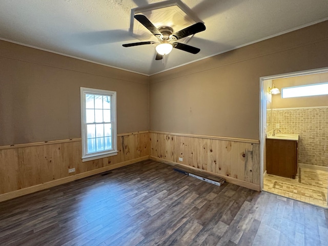 empty room with ceiling fan, ornamental molding, dark hardwood / wood-style floors, and sink