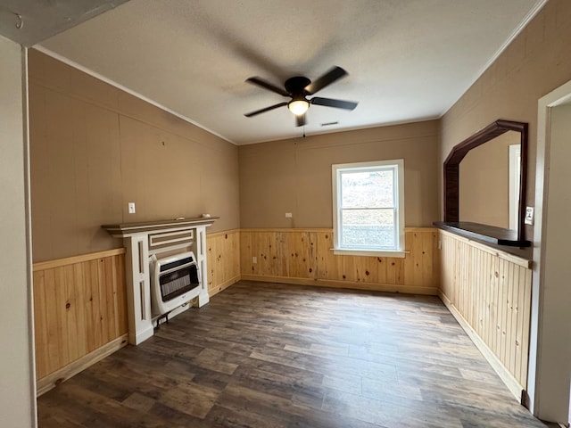 unfurnished living room featuring dark wood-type flooring, ceiling fan, heating unit, ornamental molding, and a textured ceiling