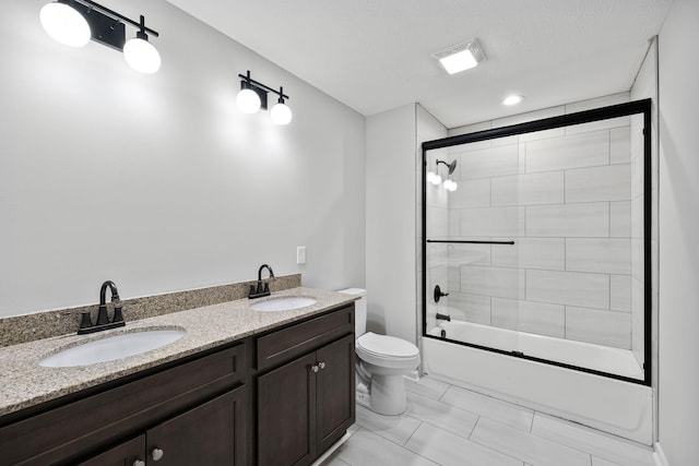 full bathroom featuring toilet, vanity, and bath / shower combo with glass door