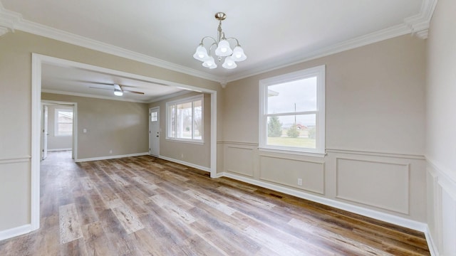 unfurnished dining area featuring ornamental molding, ceiling fan with notable chandelier, and light hardwood / wood-style flooring