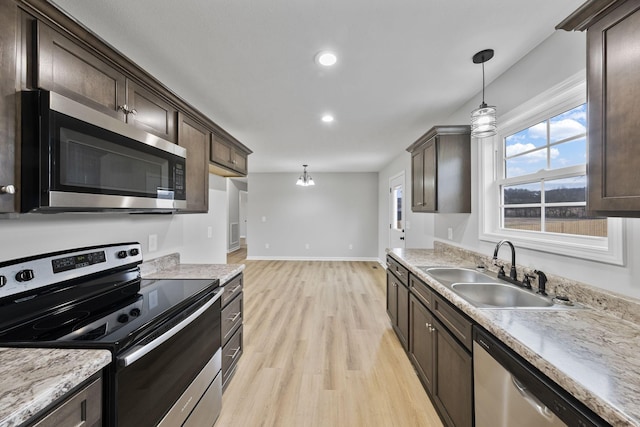 kitchen featuring sink, dark brown cabinets, hanging light fixtures, and appliances with stainless steel finishes