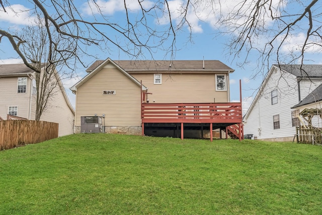 rear view of house with a wooden deck, cooling unit, and a lawn