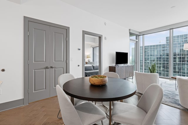 dining area with floor to ceiling windows and light parquet floors