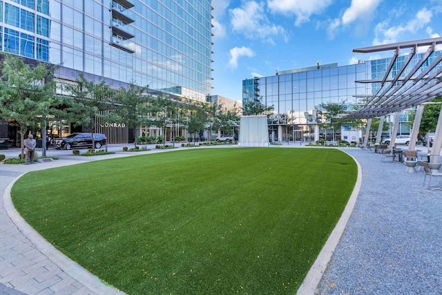 surrounding community featuring a pergola and a lawn