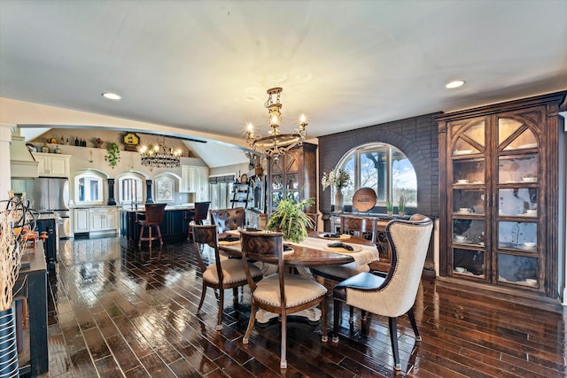 dining space featuring a chandelier, dark wood-style flooring, vaulted ceiling, and recessed lighting