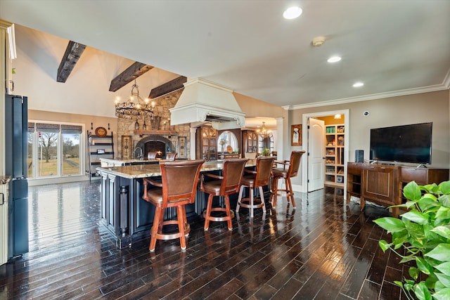 kitchen with dark wood finished floors, light stone countertops, a kitchen bar, a chandelier, and pendant lighting