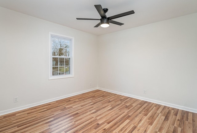 spare room with a ceiling fan, light wood-style flooring, and baseboards