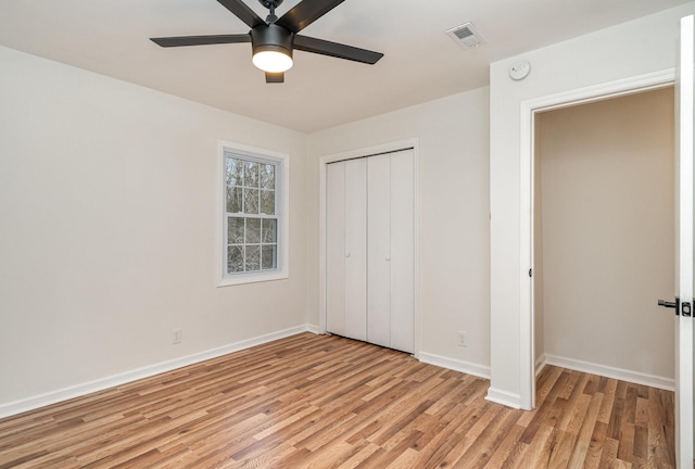 unfurnished bedroom with ceiling fan, light wood-style flooring, visible vents, baseboards, and a closet