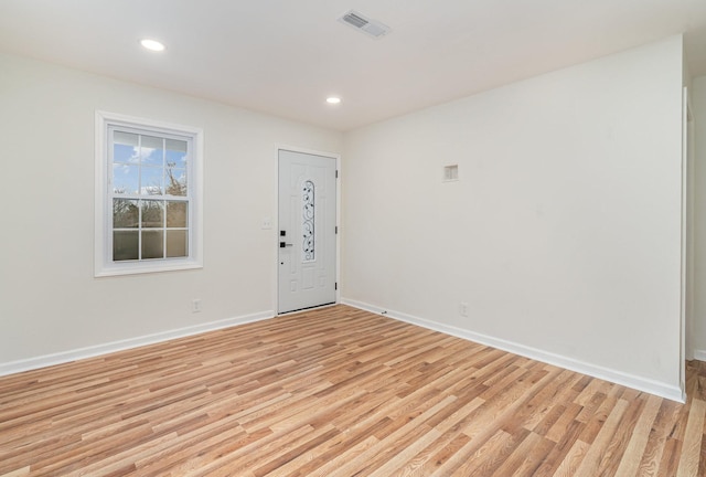 unfurnished room with light wood-style flooring, visible vents, and baseboards