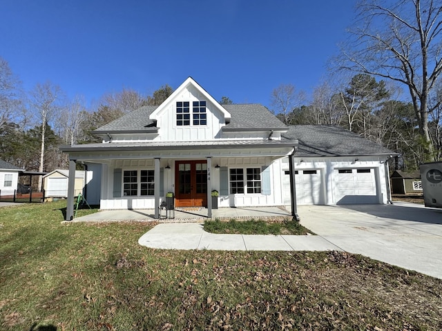 view of front facade with a garage, french doors, covered porch, and a front lawn