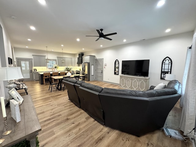 living room featuring ceiling fan and light wood-type flooring