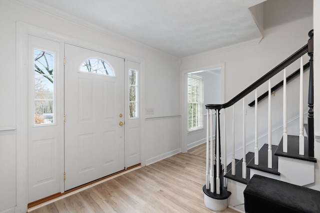 entrance foyer featuring ornamental molding and light wood-type flooring