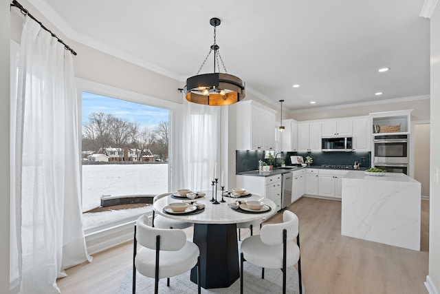 dining space with ornamental molding, light wood-style flooring, and recessed lighting