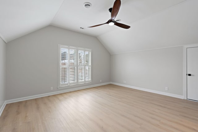 additional living space featuring lofted ceiling, light wood-style flooring, visible vents, and baseboards