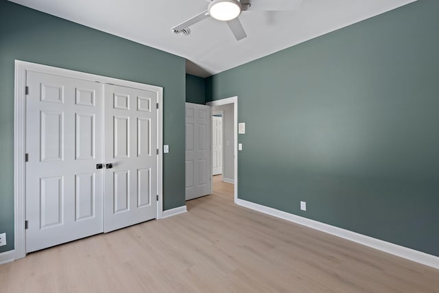 unfurnished bedroom featuring light wood finished floors, a closet, visible vents, ceiling fan, and baseboards