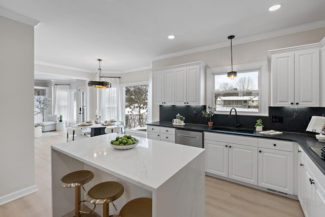 kitchen featuring pendant lighting, white cabinetry, and a sink