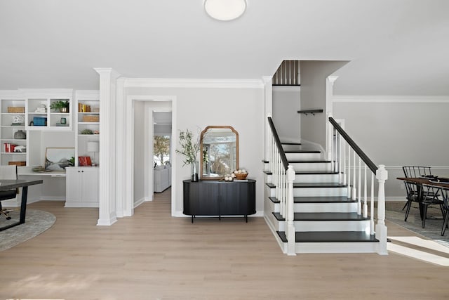 stairs featuring crown molding, baseboards, and wood finished floors