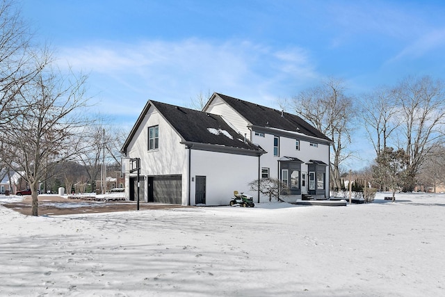 snow covered house with stucco siding