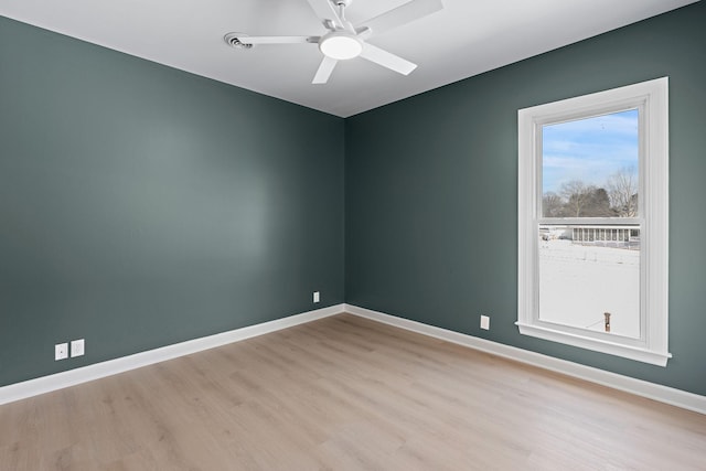 unfurnished room featuring light wood-style flooring, baseboards, and a ceiling fan