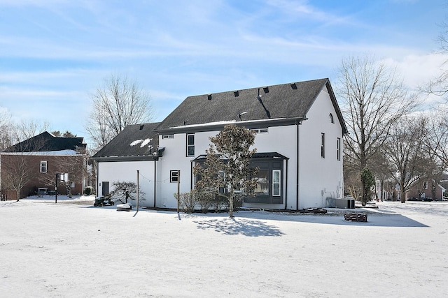 snow covered rear of property with central AC unit