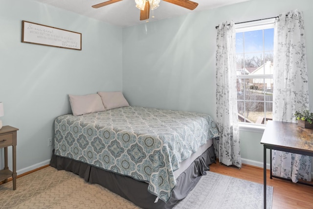 bedroom with ceiling fan, light hardwood / wood-style floors, and multiple windows