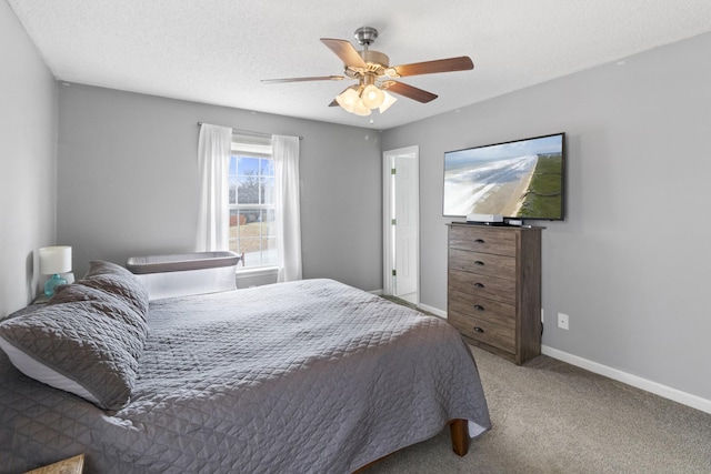 bedroom with ceiling fan, carpet floors, and a textured ceiling